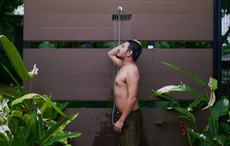 uomo sotto la doccia tropicale