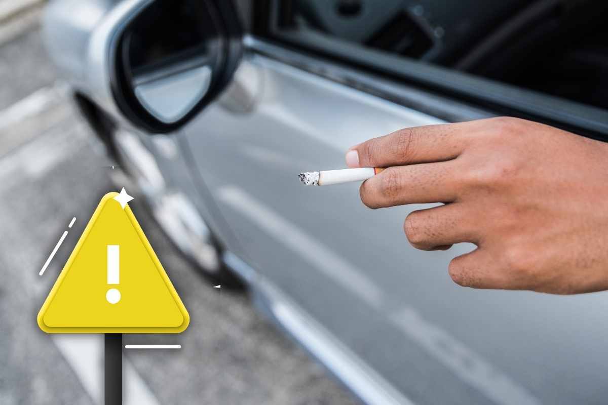 uomo che fuma in auto e segnale di pericolo